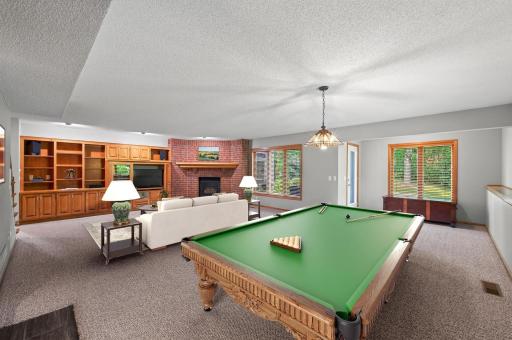 Expansive walkout family room featuring a second gas fireplace and built-in cabinetry.