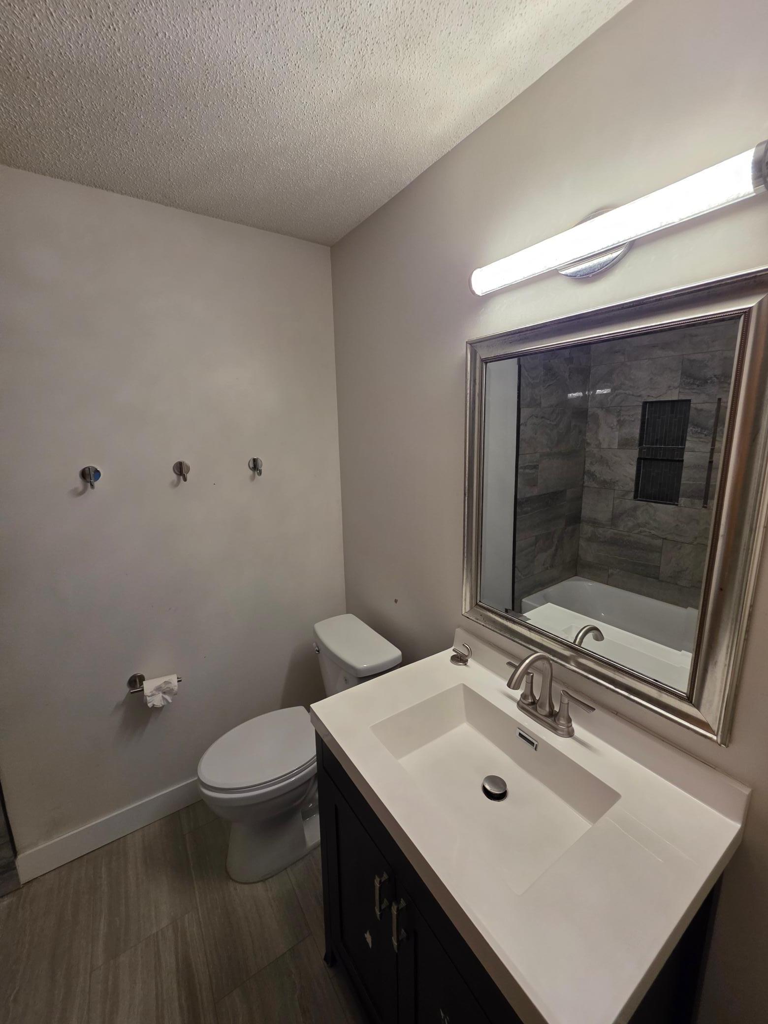 Updated bathroom with a modern vanity, tiled tub surround, and contemporary fixtures.260710_153249.jpg