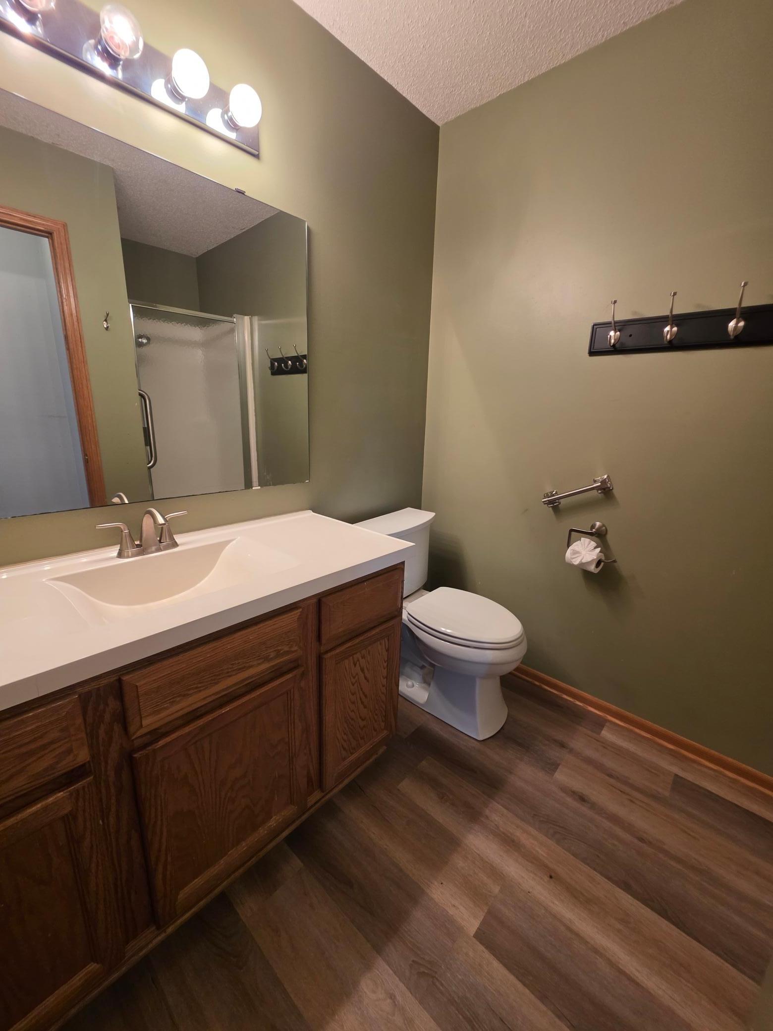 Convenient bathroom with a large vanity, updated flooring, and ample wall space for finishing touches.