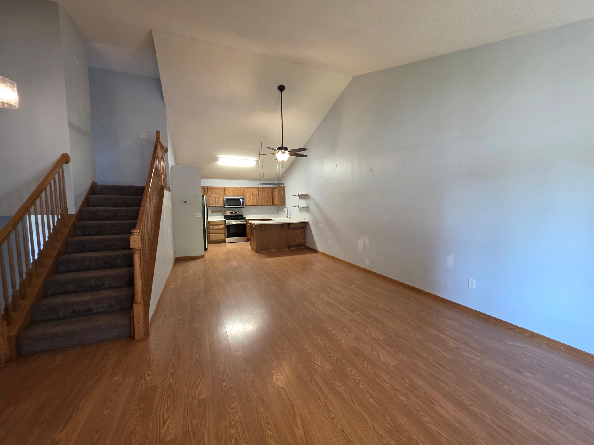 Open-concept main level with vaulted ceilings, wood-look flooring, and flexible living and dining space.