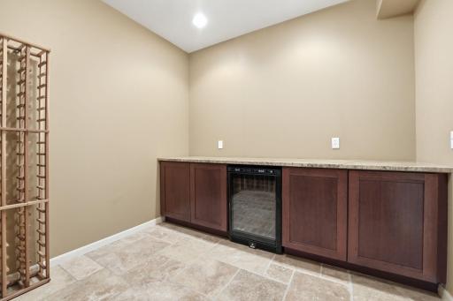 Lower level wine room! Complete with wine racks, built in cabinets, wine fridge, and granite countertop!