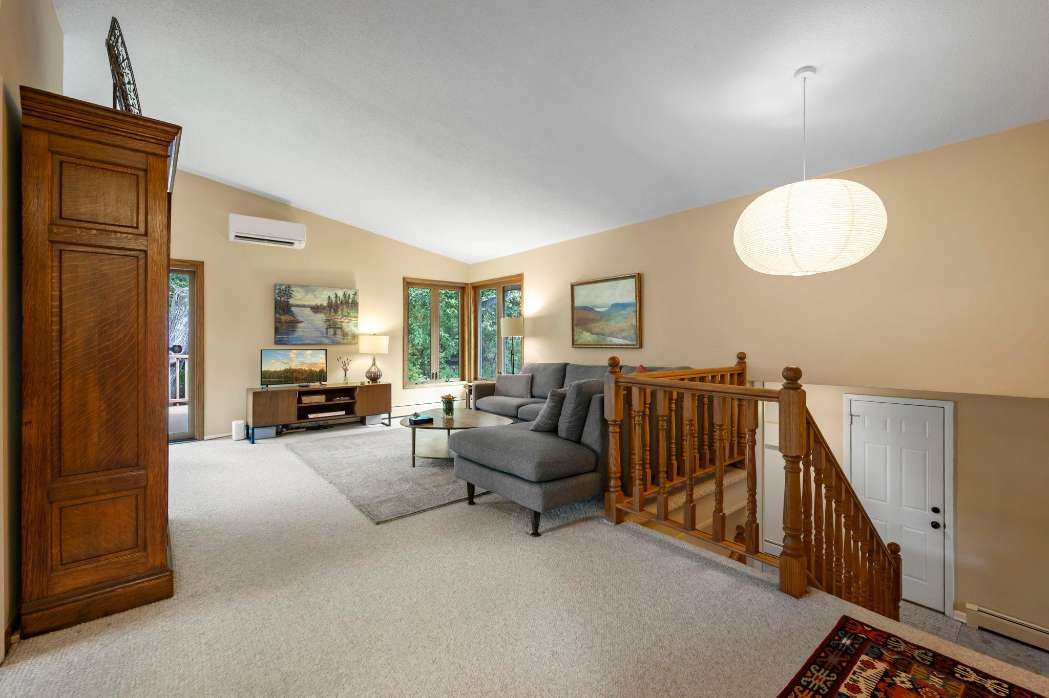 Bright living room with vaulted ceiling and views to backyard