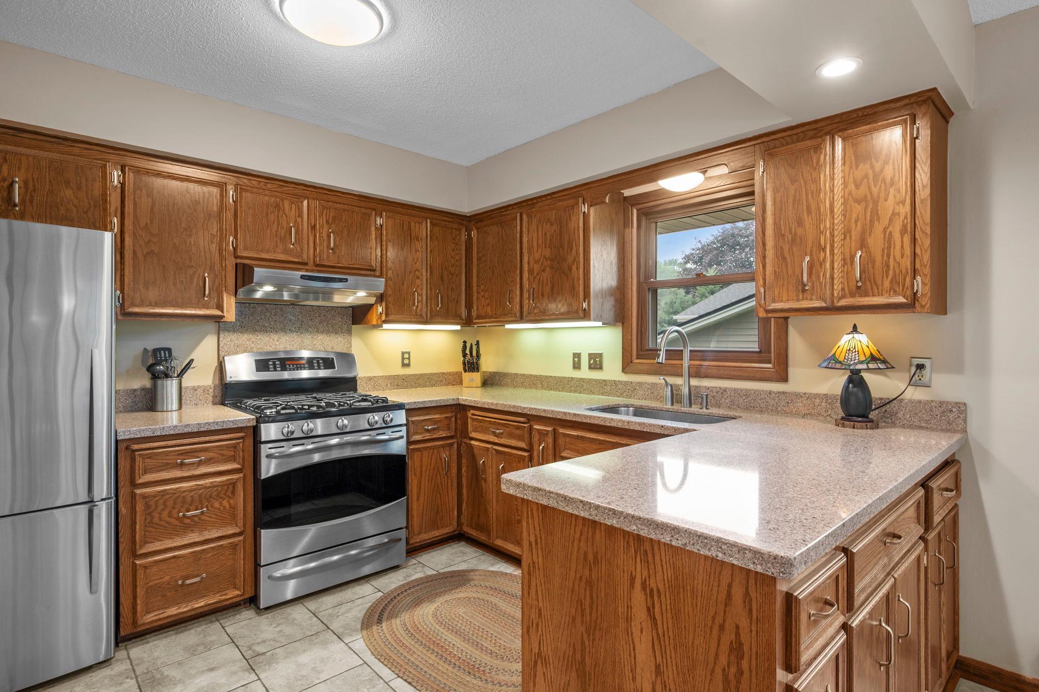 Open kitchen with lots of counter space, gas stove, vent hood, corian counter tops