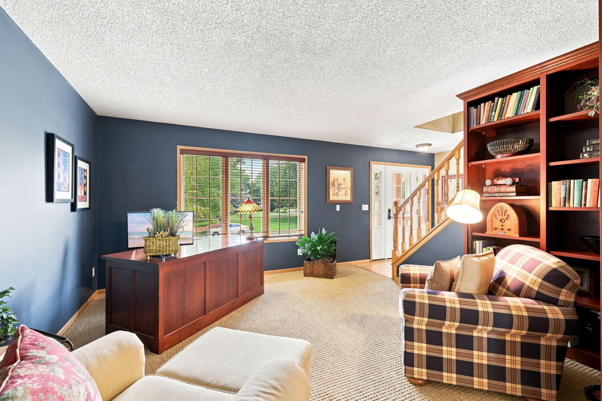 Large front room currently used as an office with built in bookshelves.
