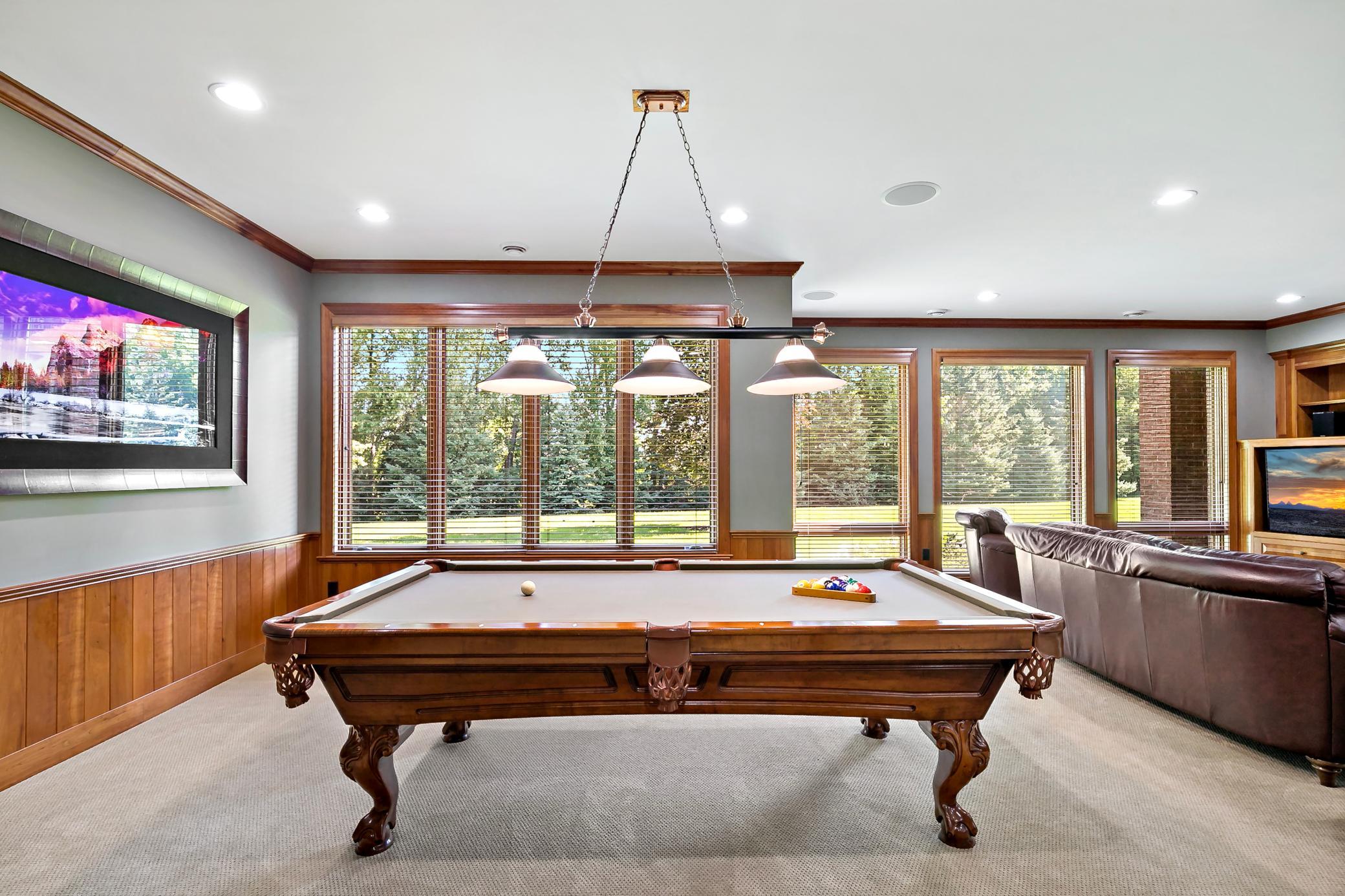 The ultimate entertainment retreat with a full wet bar, game room, custom stonework, and seamless walkout access to the backyard.