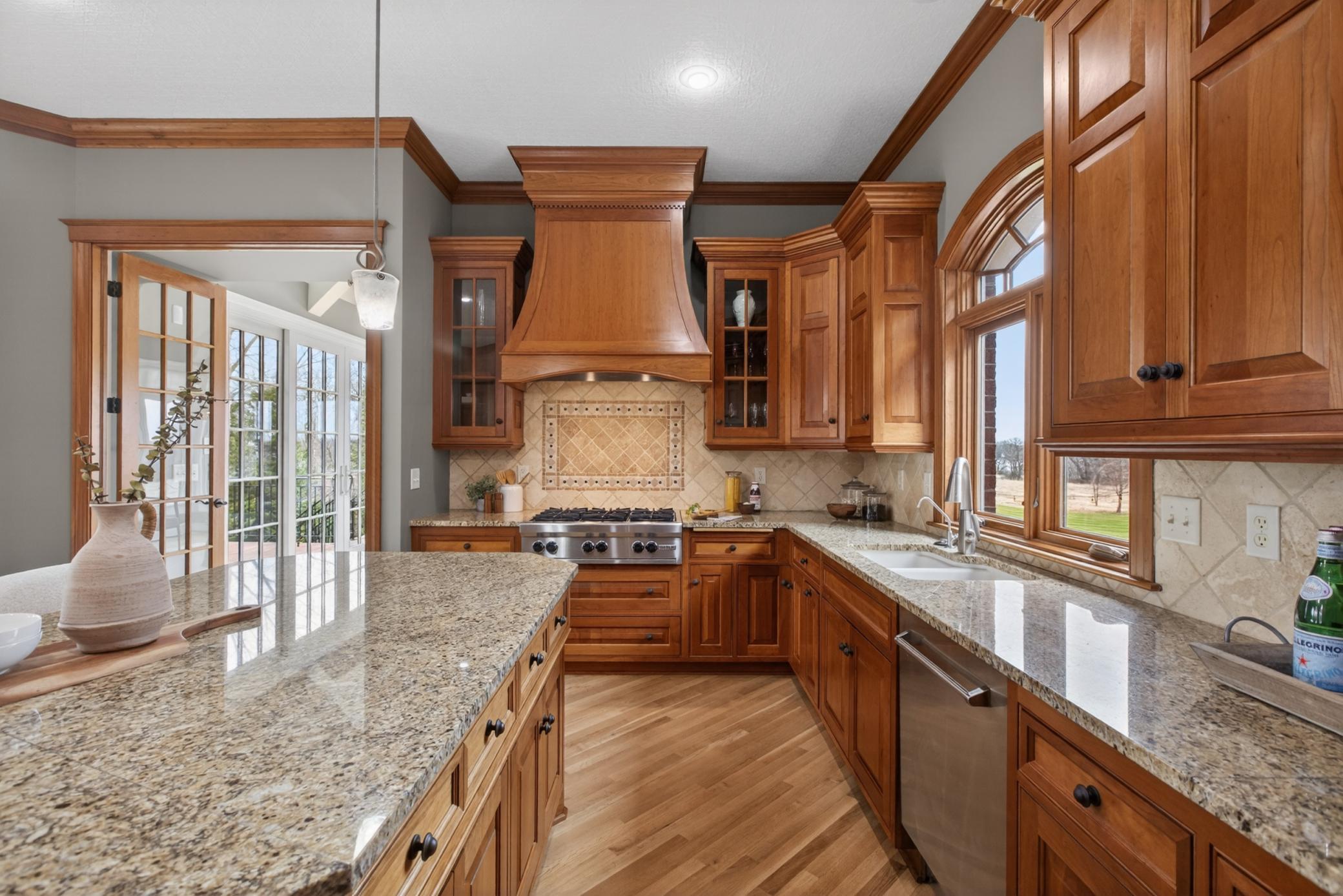 Custom cherry wood cabinetry anchors this gourmet kitchen, offering timeless craftsmanship and exceptional storage.