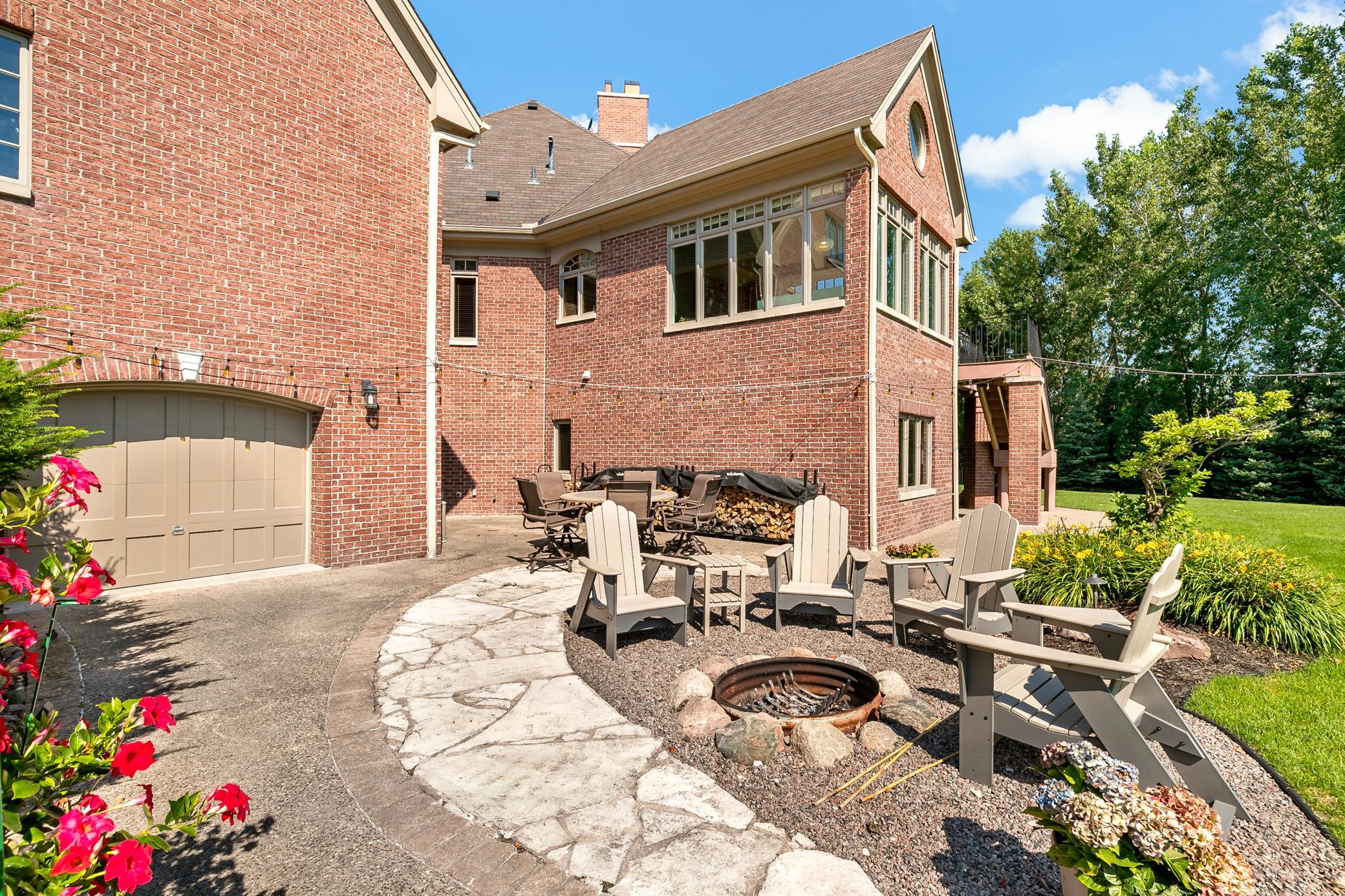 The heated workshop opens directly to this private backyard retreat, featuring an all-brick exterior, mature landscaping, and exceptional outdoor living space.