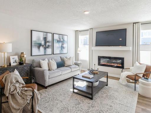 Spacious Harmony living room with two windows and electric fireplace.
