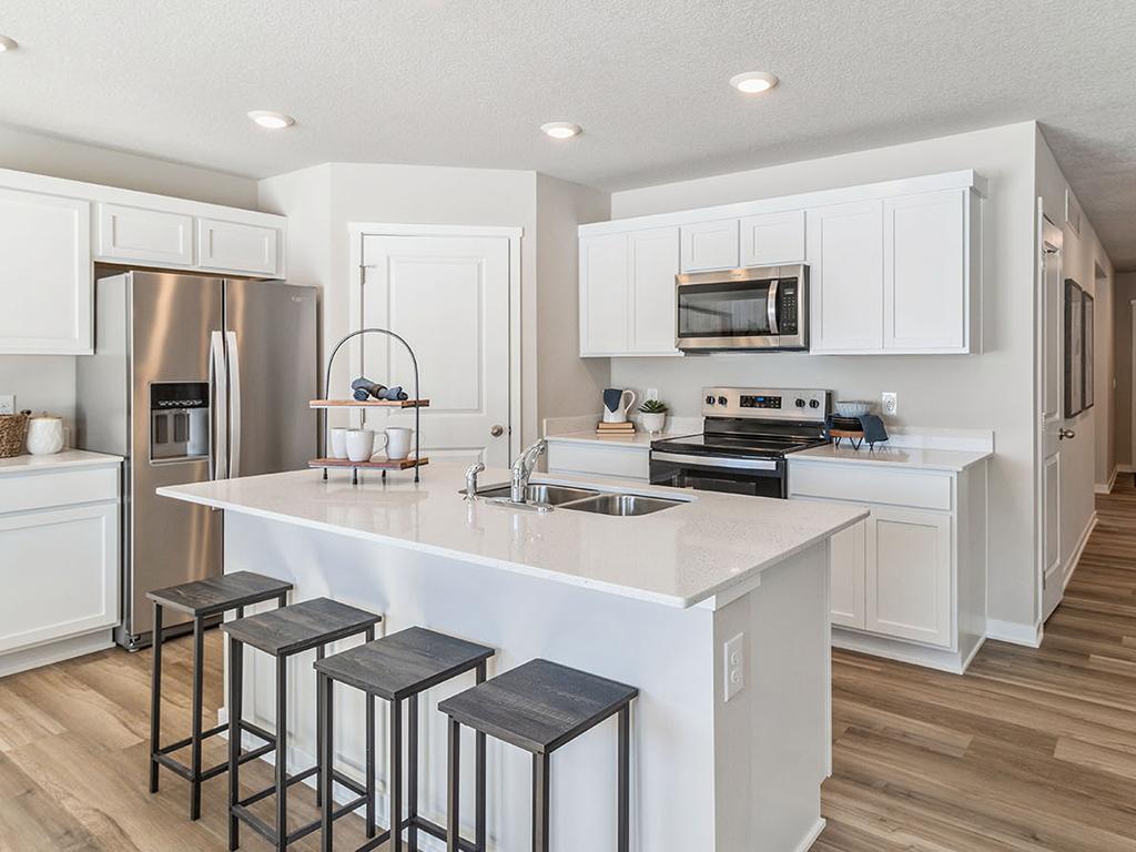 Photo for 955 Greenlawn Avenue, Delano, MN 55328 - Listing #7110879 Modern white kitchen with quartz countertops and island.
