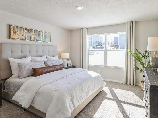 Bedroom suite with large white bed and large window.