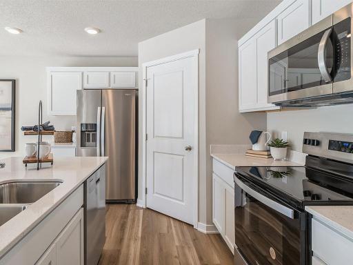 Side view of kitchen with stainless-steel appliances and quartz countertops.