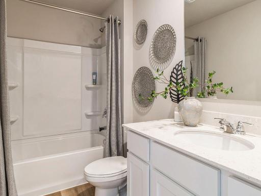First bathroom with large mirror and shower and bathtub.