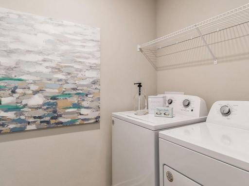Laundry room with shelving and washer and dryer.