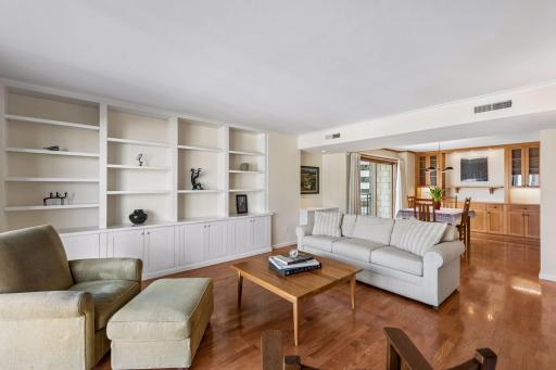 Open and spacious floor plan with beautiful custom built in shelving and cabinetry in both the living room and dining area.