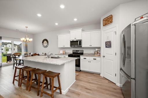 Spacious kitchen outfitted with granite countertops, stainless steel appliances, a gas range, center island and a walk-in pantry!