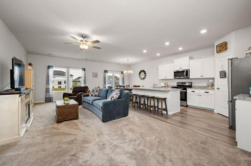 The heart of the home features a spacious kitchen outfitted with granite countertops, center island, stainless steel appliances, a gas range, and a walk-in pantry