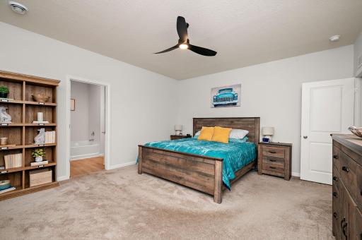 The expansive primary suite serves as a true private retreat, featuring a walk-in closet, double vanity sink, granite countertops, a large soaker tub, and a separate walk-in shower