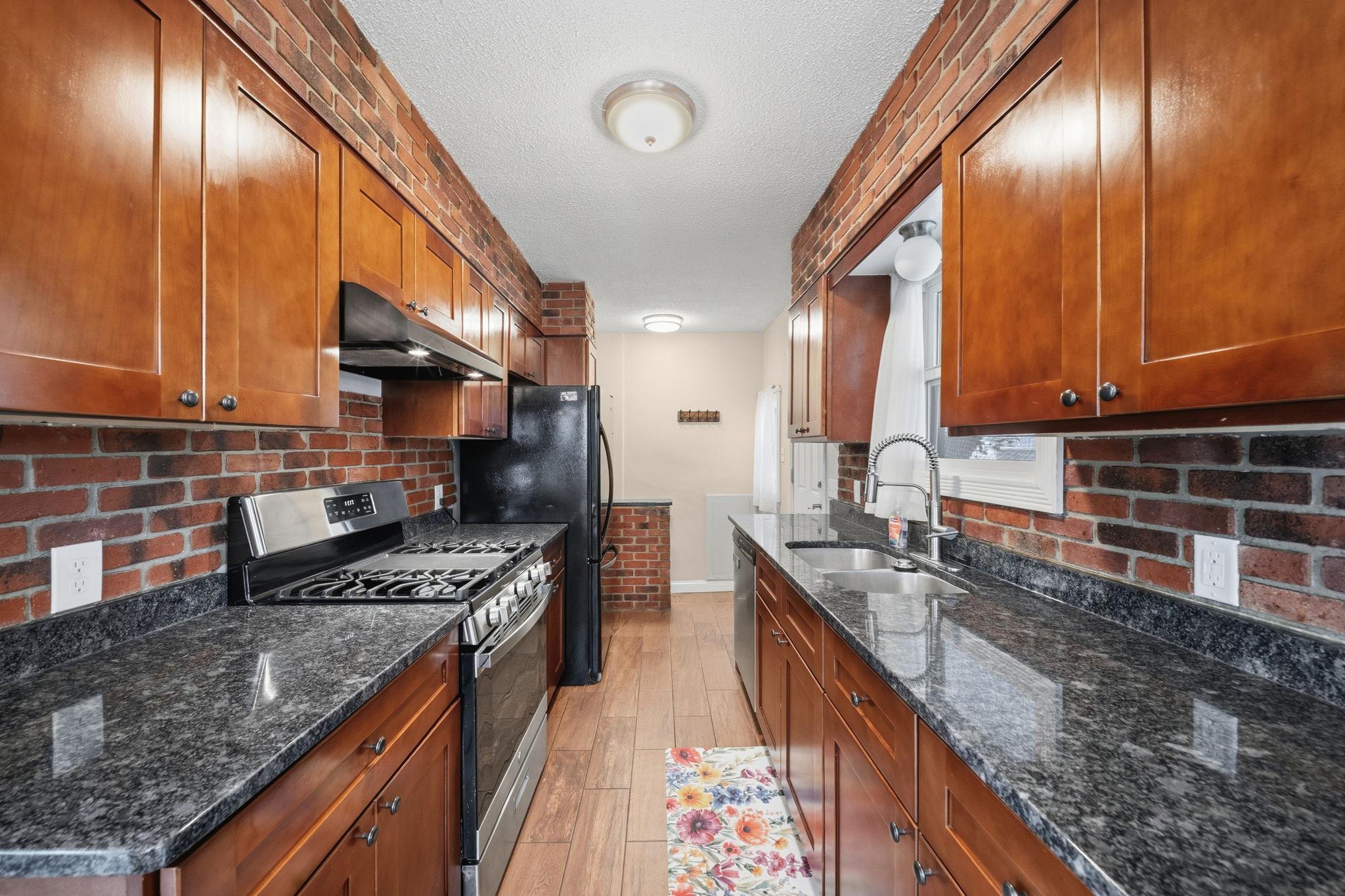 Brick walls rise floor to ceiling as the space narrows into pure function, everything exactly where you need it. Cook here and the whole kitchen works with you, not against you.