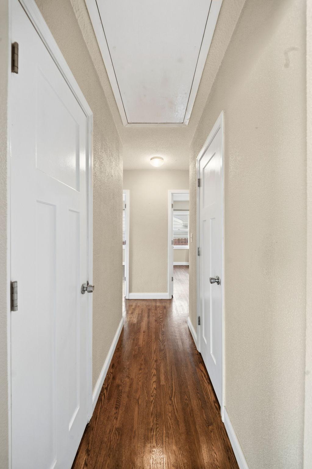 A hallway lined with bedroom doors, each one leading to a place to rest, recharge, and close out the noise of the day.