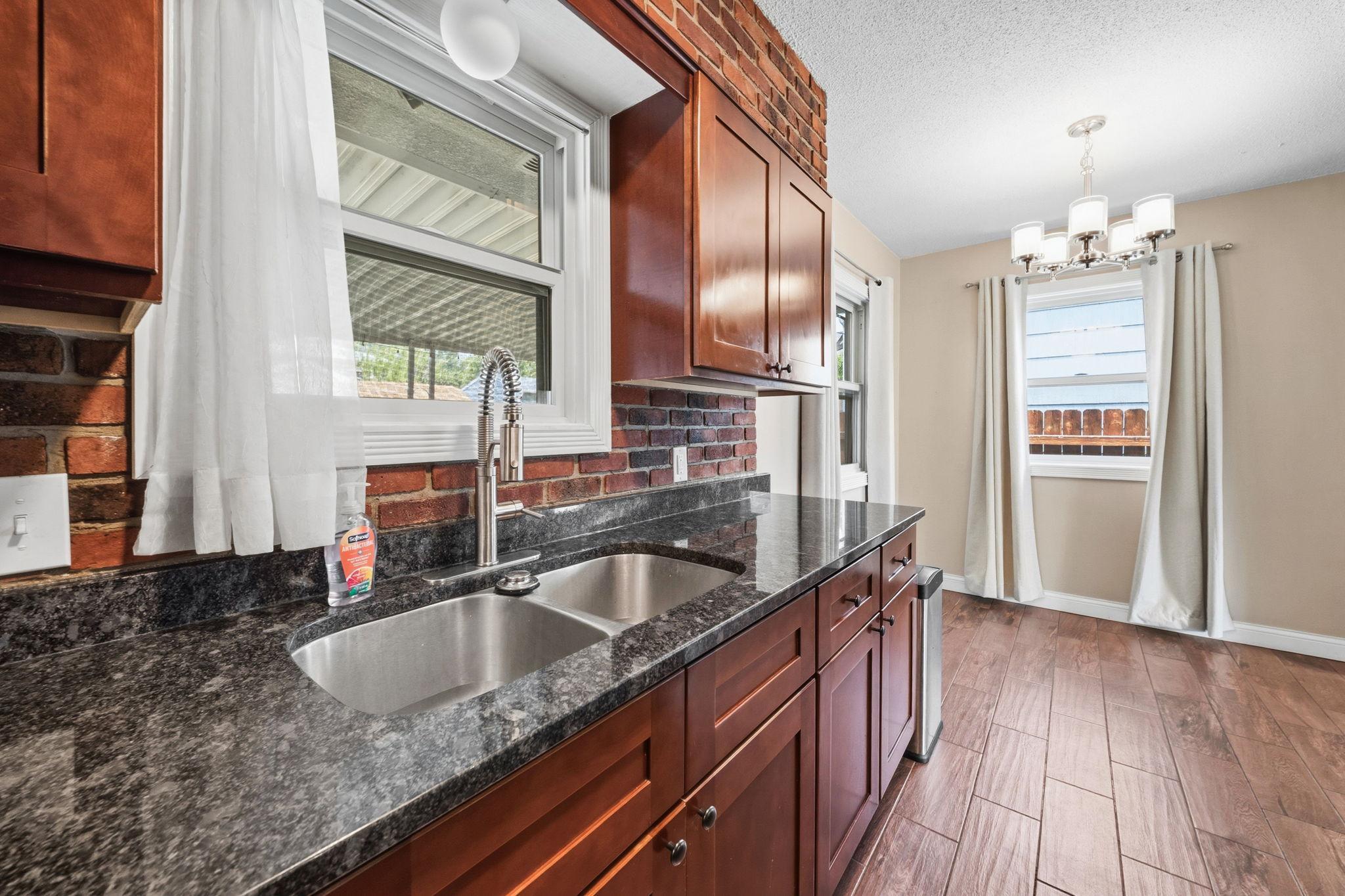 A deep stainless double sink positioned right at the window. Wash dishes with a view of the backyard instead of a blank wall.