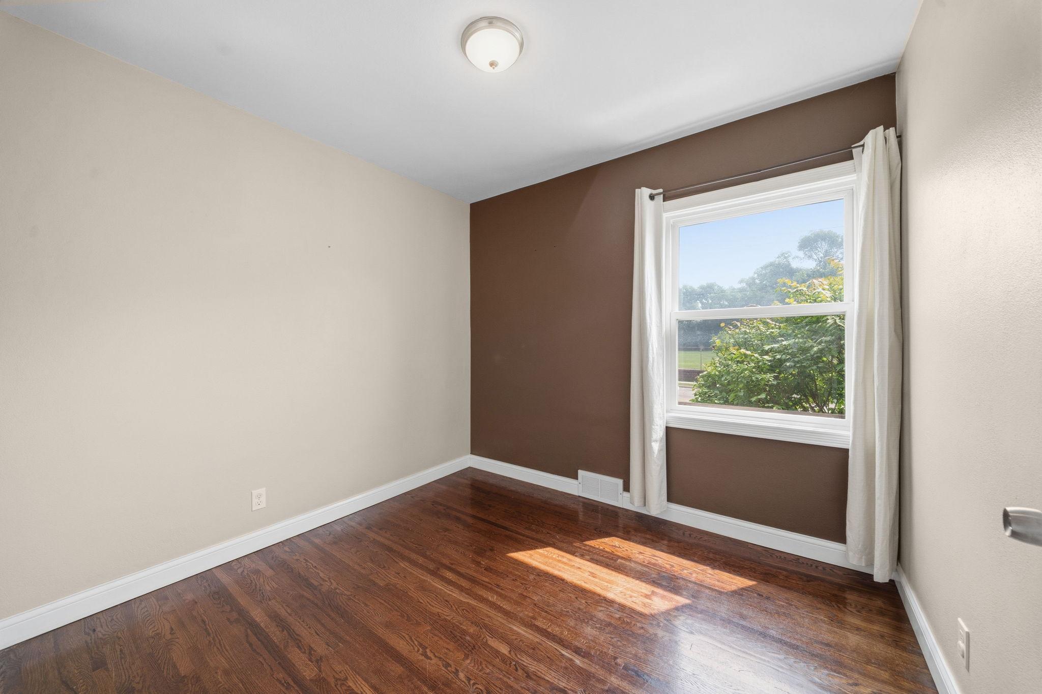 From this angle the room opens up a little more, light spilling toward the hallway just beyond. Plenty of space to picture where the bed, the dresser, the whole next chapter goes.