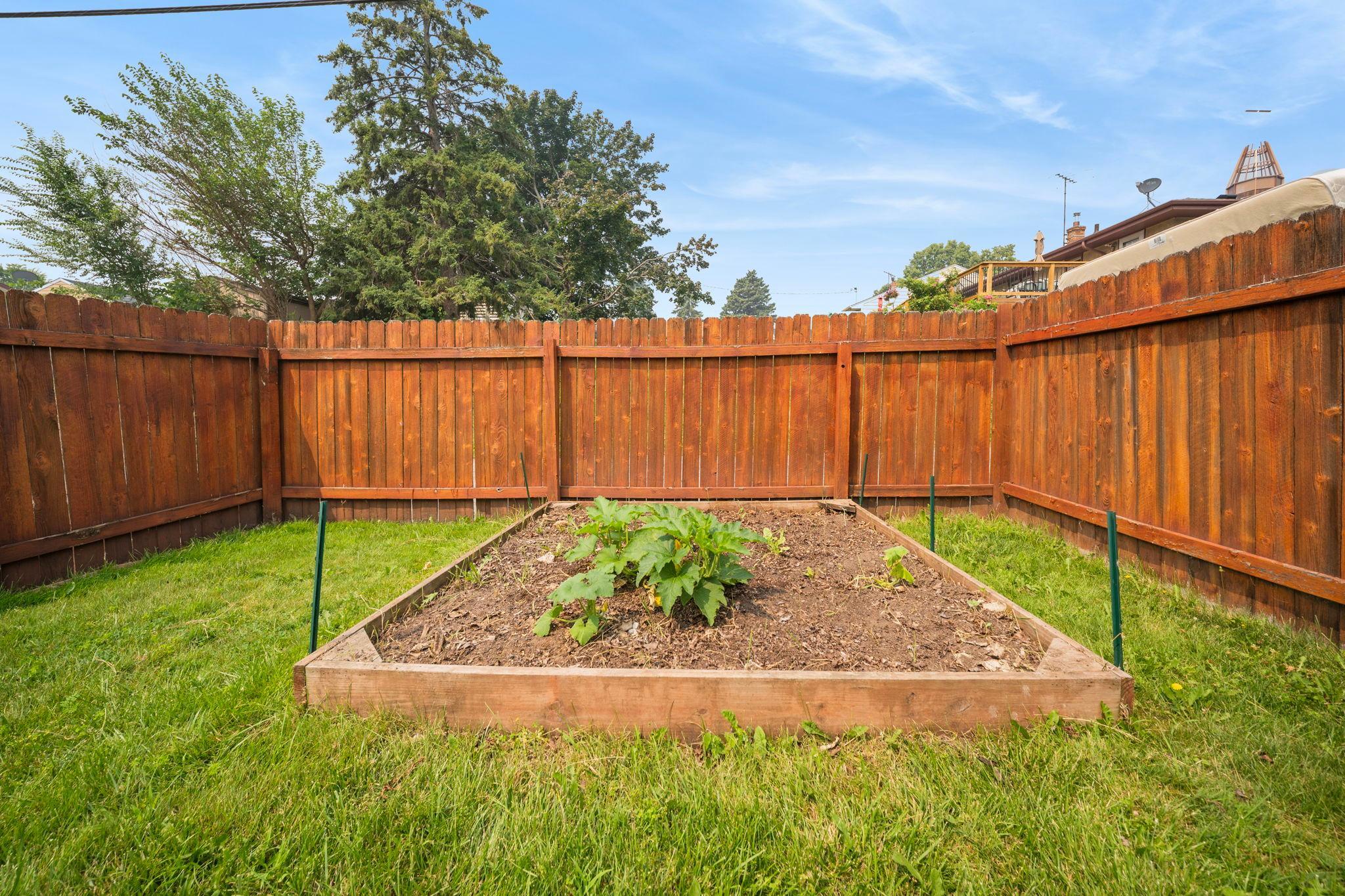 A private garden bed tucked against the fence line. Grow tomatoes, herbs, or flowers in a yard that is fully fenced and all yours.