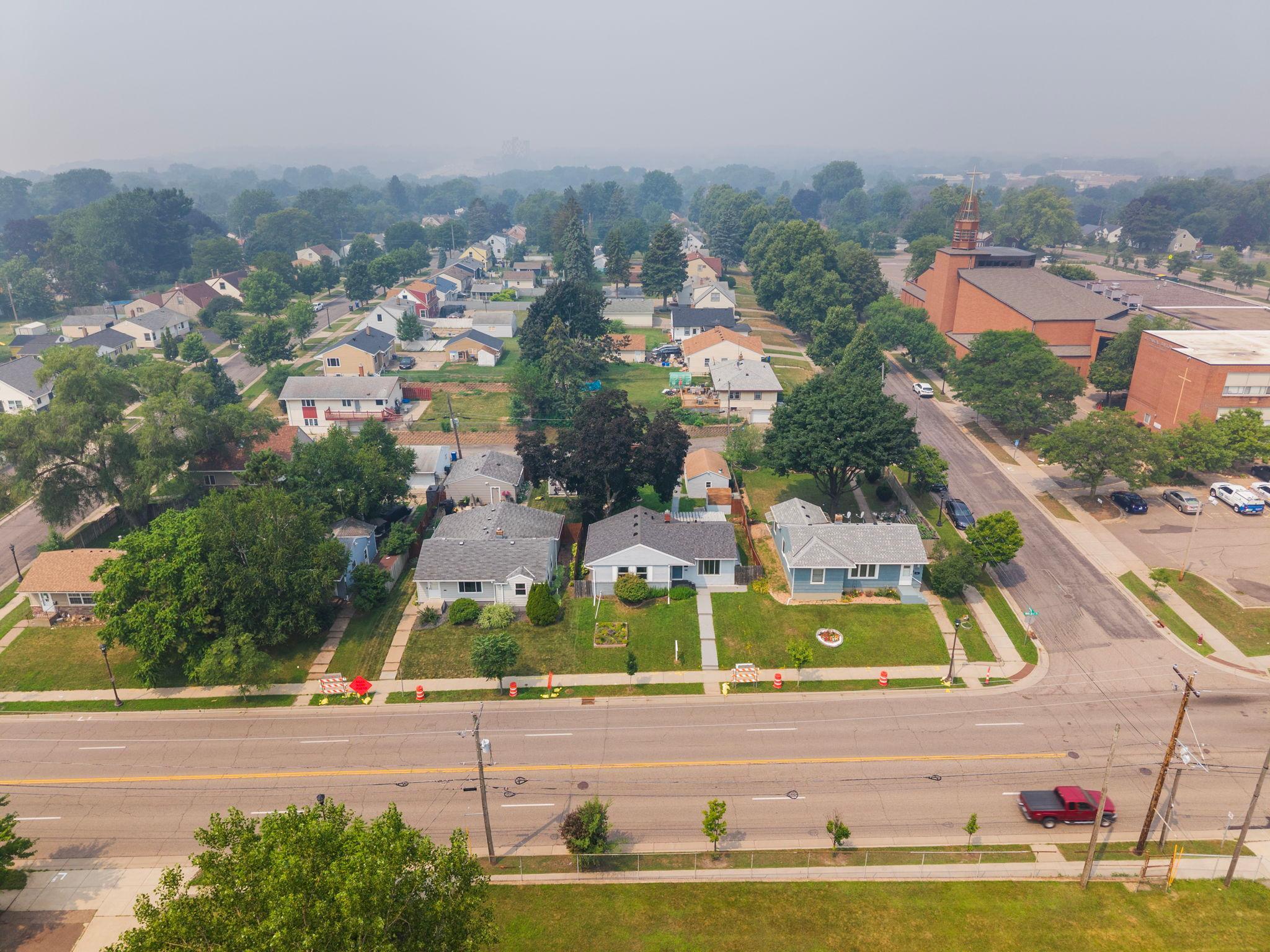 An aerial view of a tree lined Saint Paul street, front porches and established landscaping as far as the eye can see. A neighborhood built for walking, waving, and knowing your neighbors.