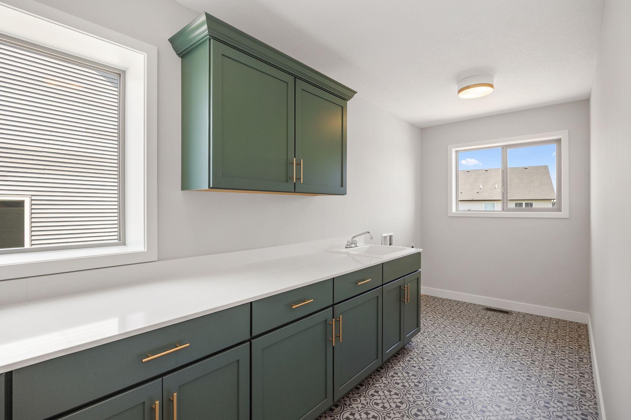 Our largest laundry room with 2 windows, upgraded cabinets and sink.