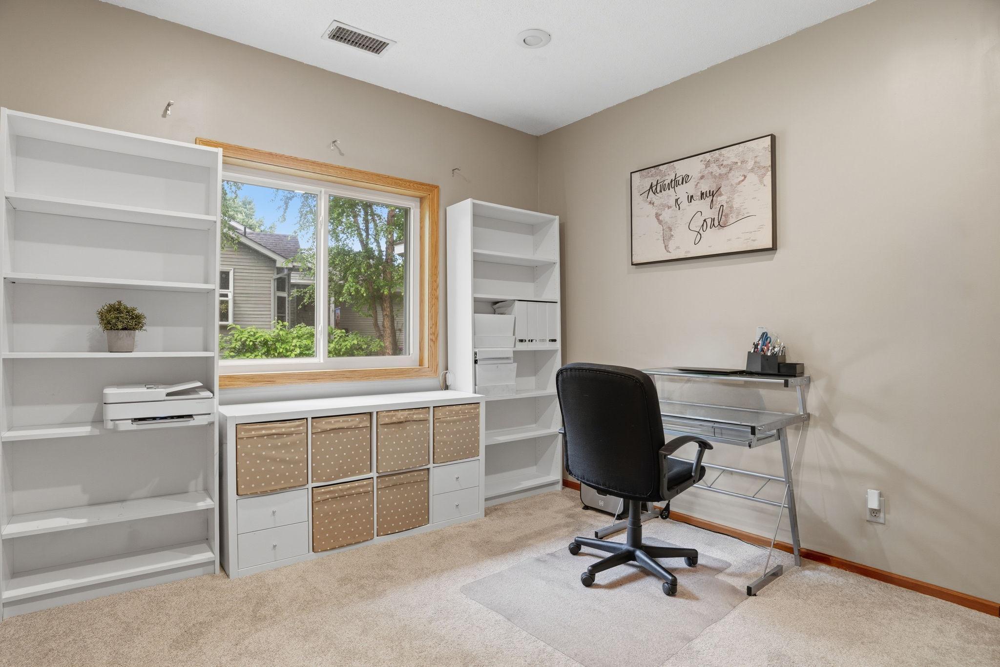 Bathed in window light, this versatile home office offers built in shelving and room for a desk, a quiet spot to work, craft or curl up with a book.