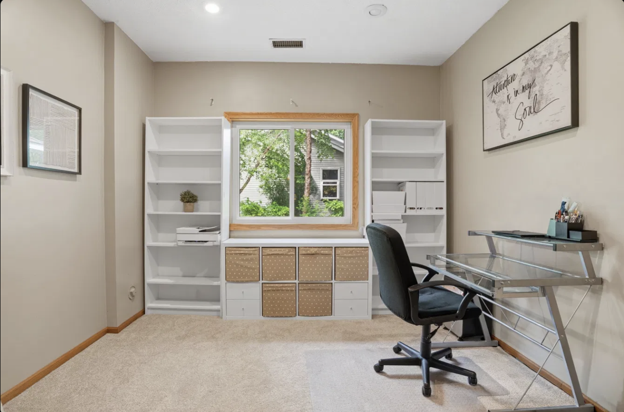 Work from home with ease in this bright, dedicated office featuring built in shelving, generous storage, and a large window that brings in beautiful natural light throughout the day.
