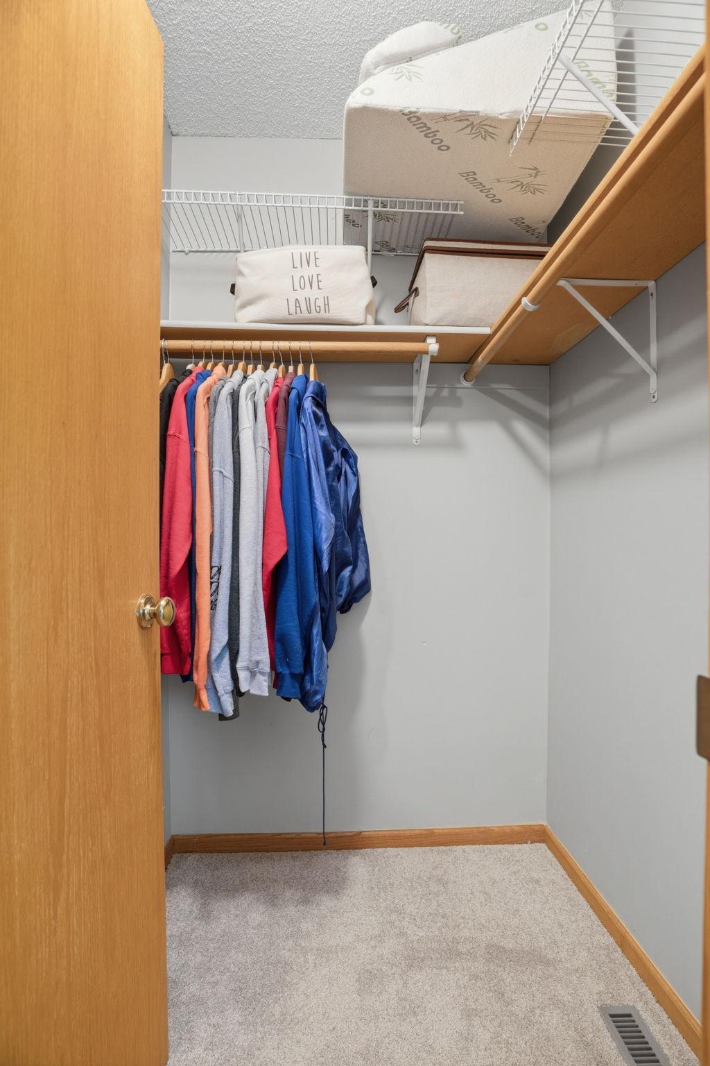 Two rods. Upper shelving. Wire basket storage above. A walk-in closet that actually holds your whole wardrobe without a fight.