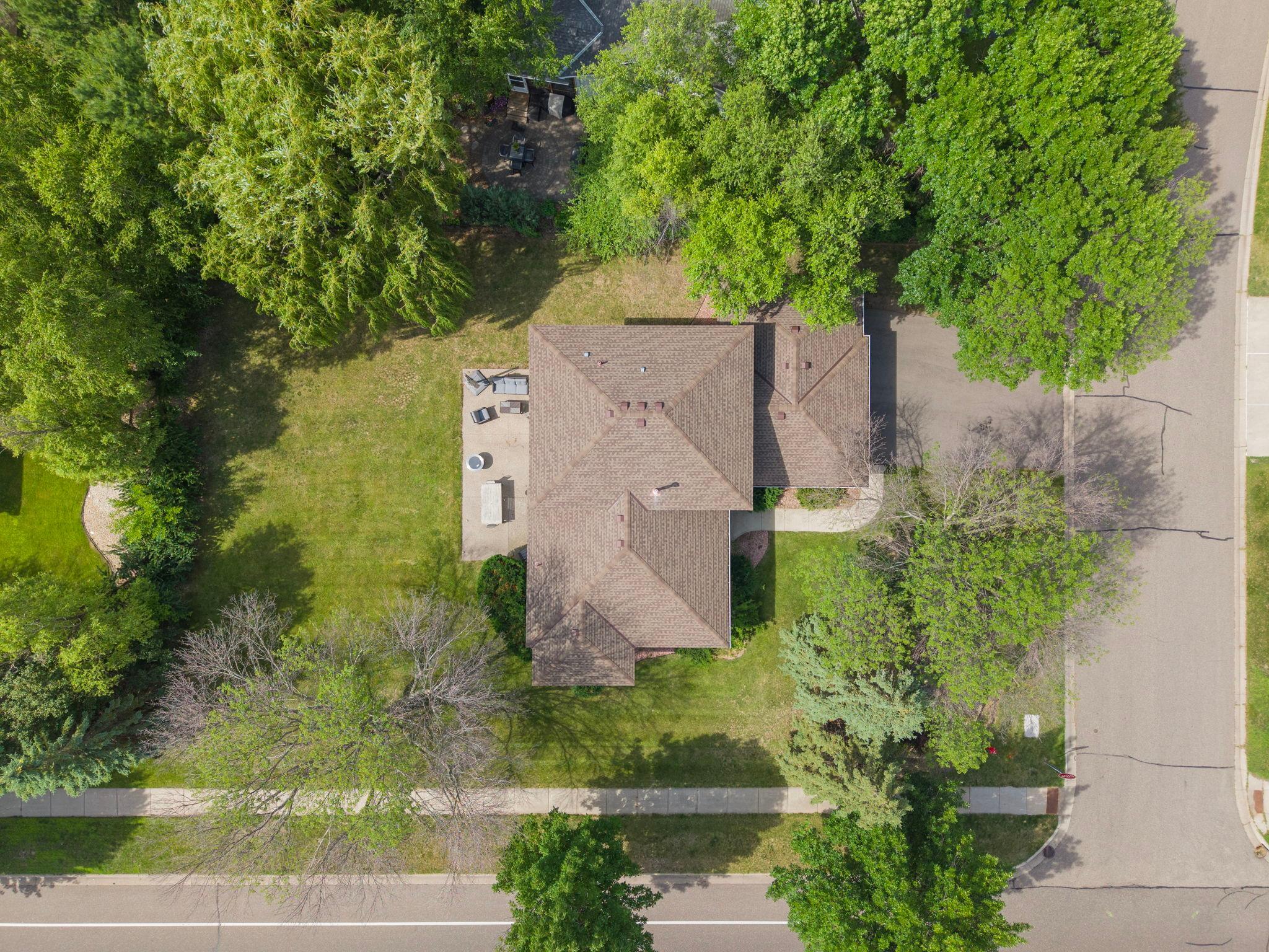 Corner lot. New roof. Trees on all sides. The full property visible from directly above. Big lot. Big trees. A home that earns its place in this neighborhood from every angle, including this one.