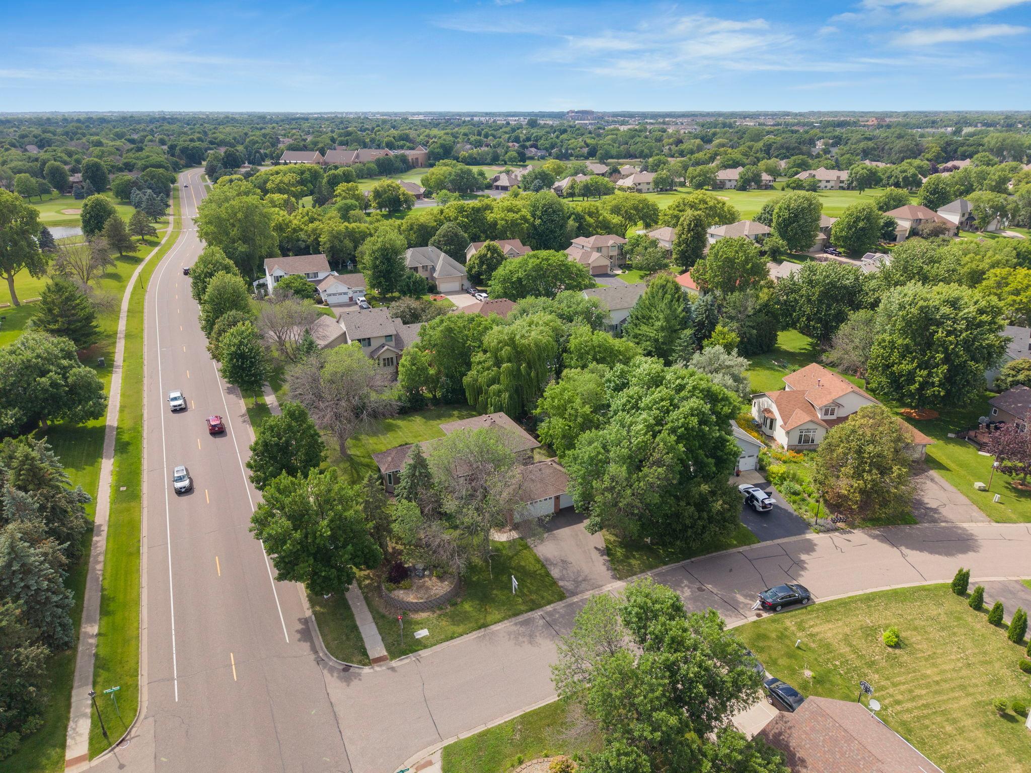 From above, the golf course spreads wide to the left and the neighborhood disappears into a canopy of green. This is Brooklyn Park at its best. And this home sits right in the middle of it.