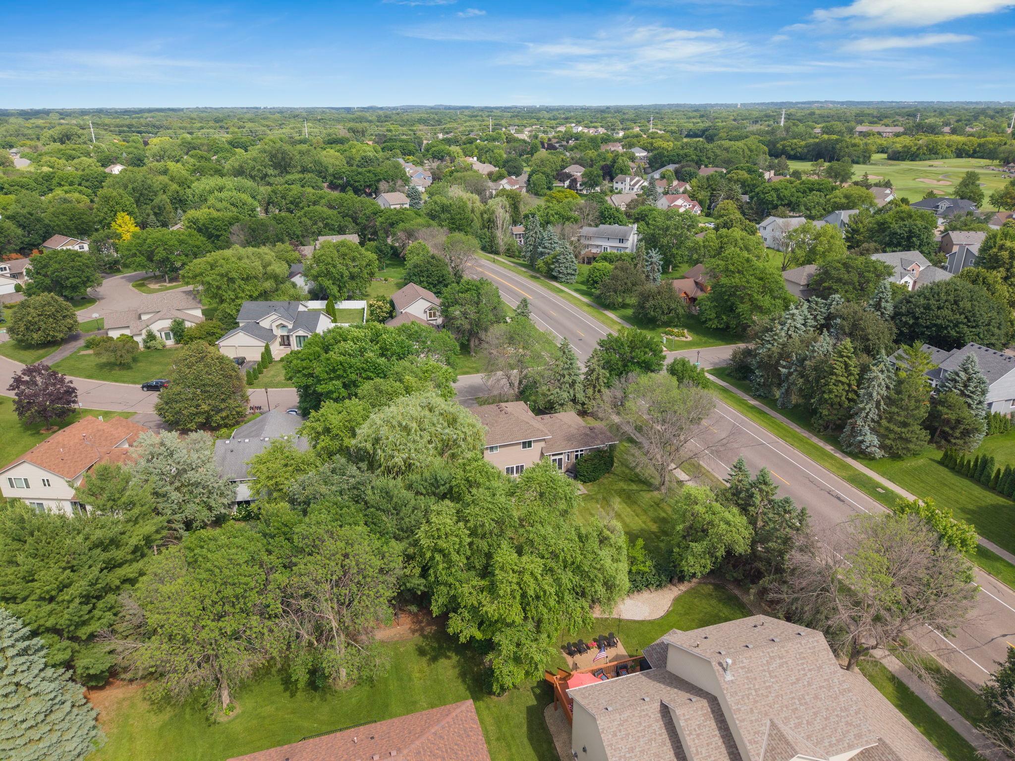 The home settles into the Heart of Edinburgh neighborhood from this angle. Wide streets. Large lots. The golf course visible in the distance. A location worth the elevation to see.