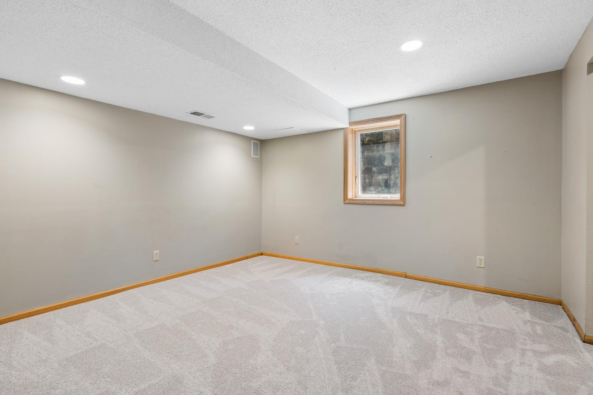 The fourth bedroom is a blank canvas. Recessed lights overhead, carpet underfoot, and a window that lets a little sky in. Whether it becomes bedroom four, a studio, or a playroom, this room is ready for the decision.