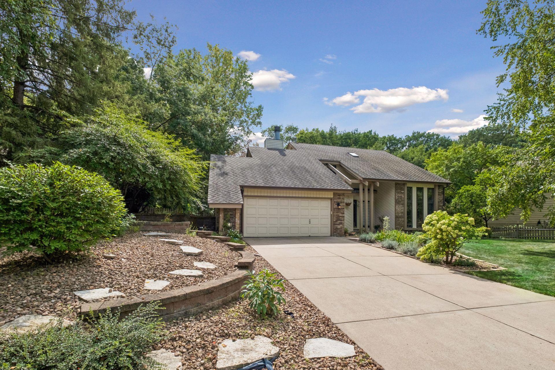 Stunning curb appeal with professional landscaping, surrounded by mature trees for added privacy.