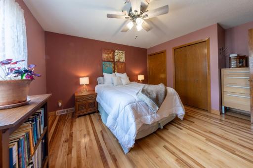 Upper level primary bedroom with hardwood floors and generous closet storage.