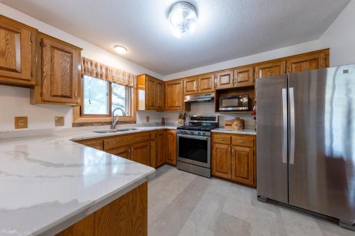 Updated kitchen with quartz surfaces, refreshed cabinetry, pull-out storage, and stainless appliances.