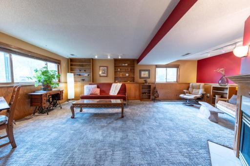 Lower level family room anchored by a cozy gas fireplace.