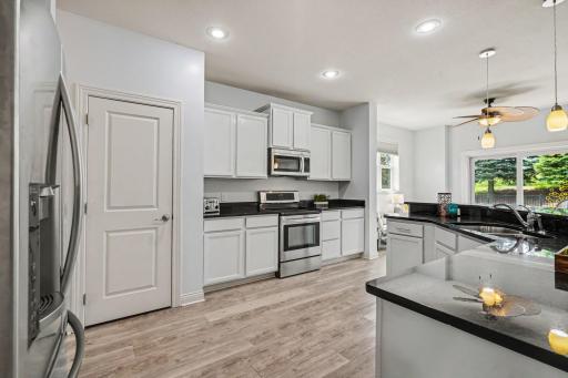 Spacious Kitchen has white cabinets and stainless steel appliances.
