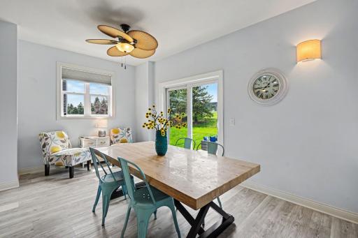 Spacious informal dining room has a ceiling fan and a sliding glass door to the backyard.