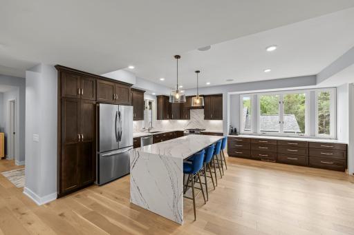 An expansive chef-inspired kitchen features rich cabinetry, a striking quartz island and generous workspace designed for gathering.