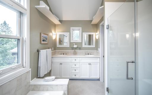 The upper bath features two vanities, a tub and a shower