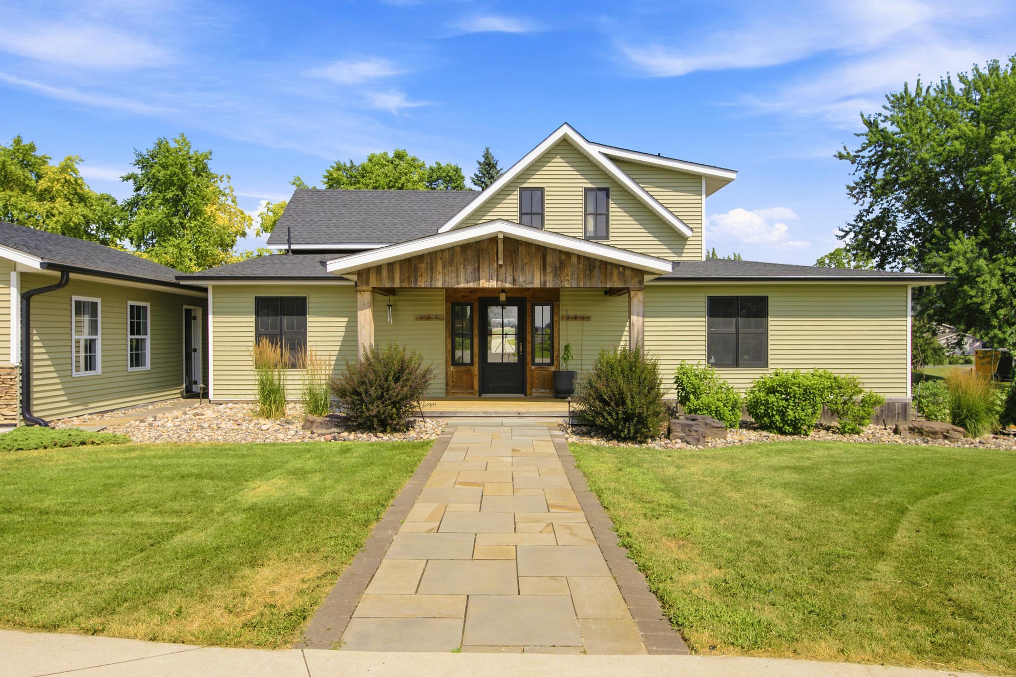 This beautifully landscaped home features a detached garage, an expansive driveway, and excellent curb appeal.