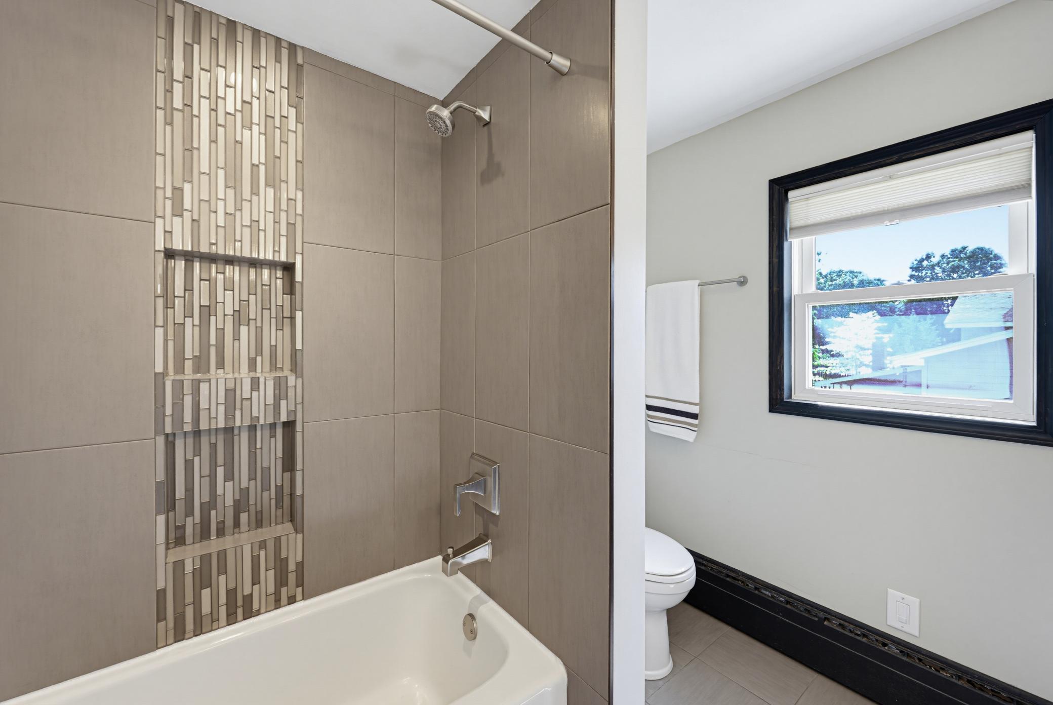 The main floor full bathroom features a tiled tub surround.