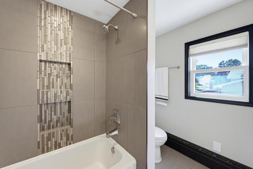 The main floor full bathroom features a tiled tub surround.