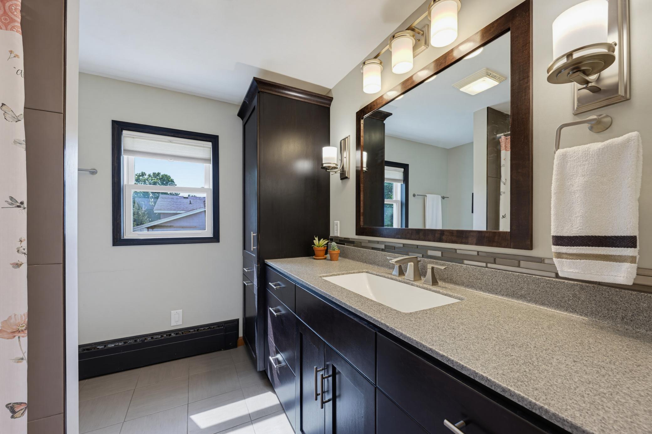 The full bathroom on the main floor features a dedicated linen cabinet.