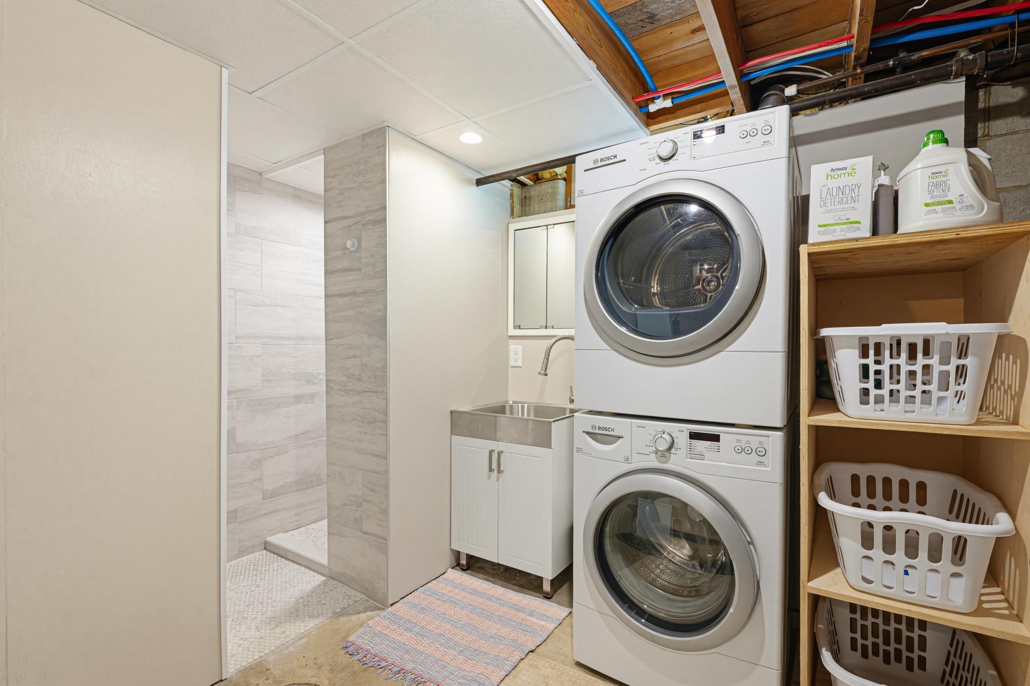 The laundry room shares space with the 3/4 bathroom in the lower level.