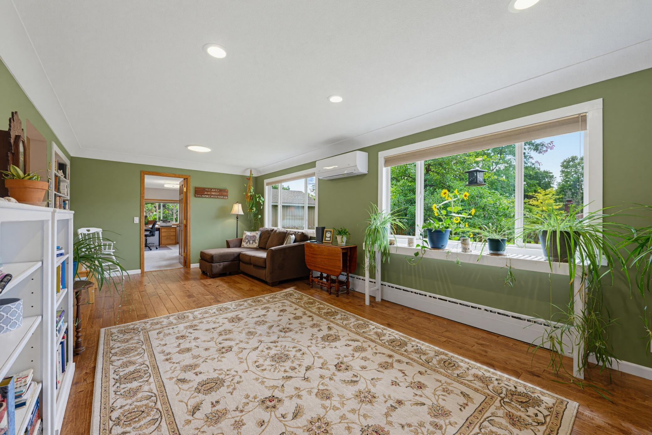 The spacious living room features wood floors. Large windows let in tons of natural light.
