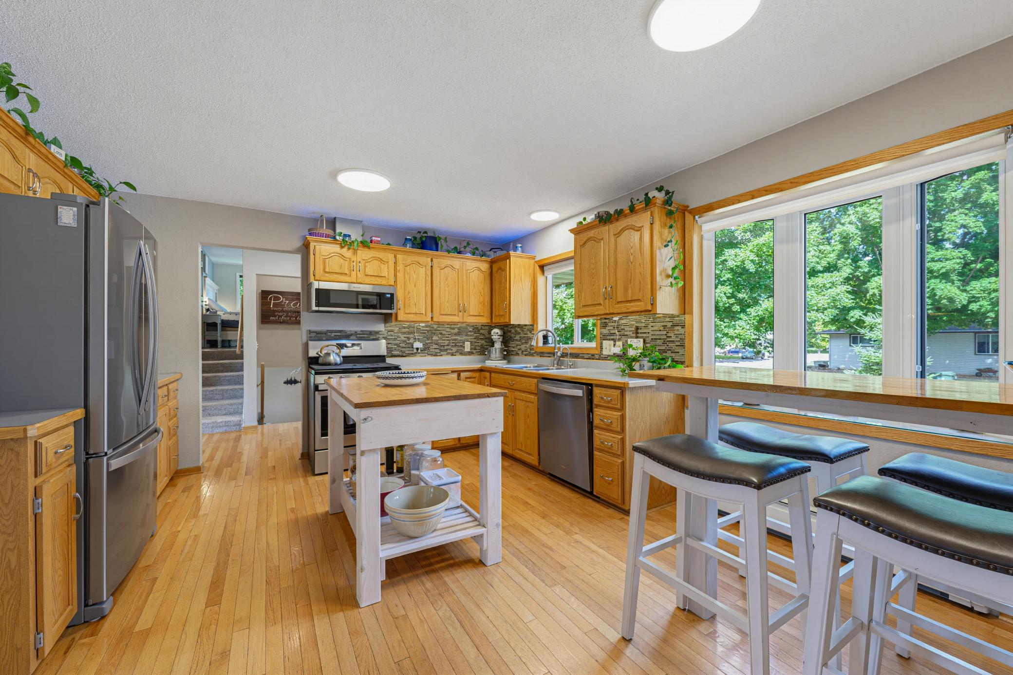 The kitchen features hardwood floors, S.S. appliances, a center island, and a dedicated pantry cabinet with pull-out drawers.
